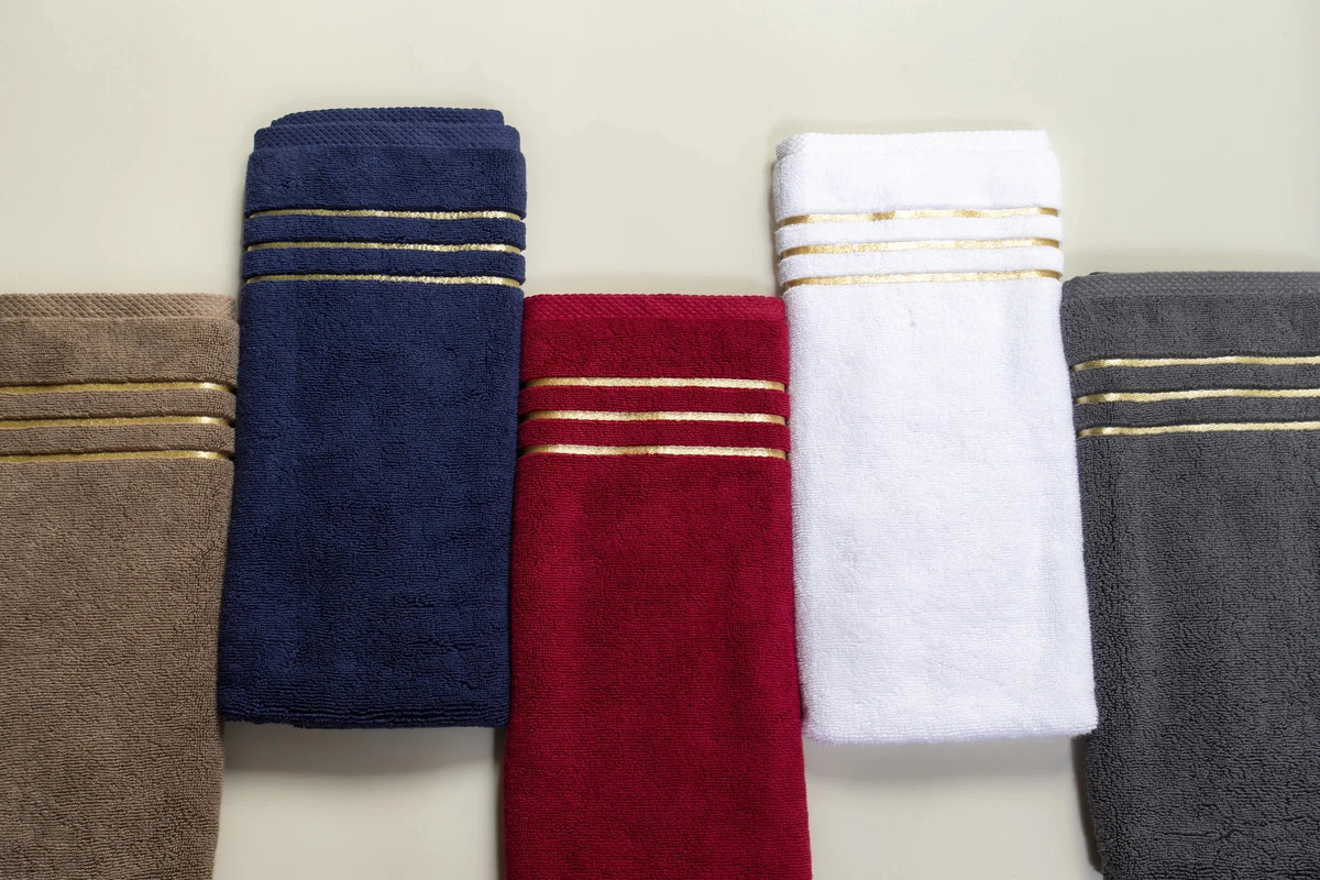 Maison 1952 Chateau Collection: five 800 GSM Turkish cotton hand towels folded in brown, navy blue, maroon, white and grey, each with a gold border