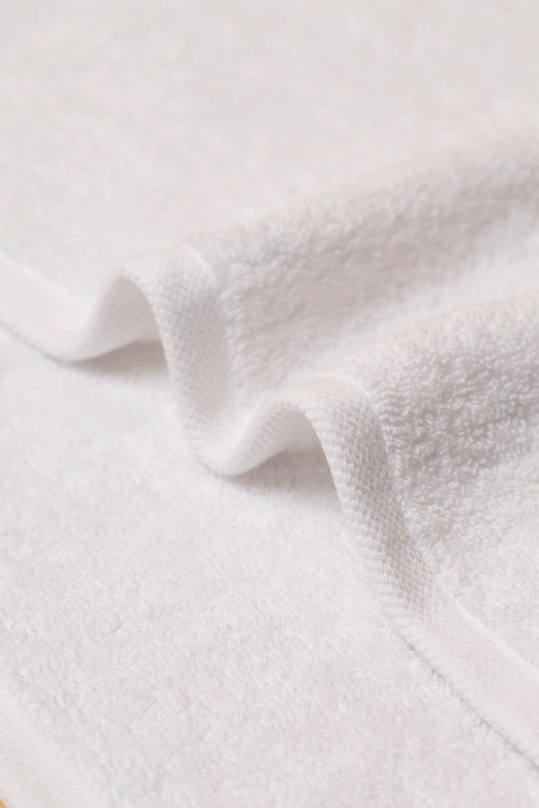 Close-up of soft white cotton terry and the flat twill hem on a Retreat towel