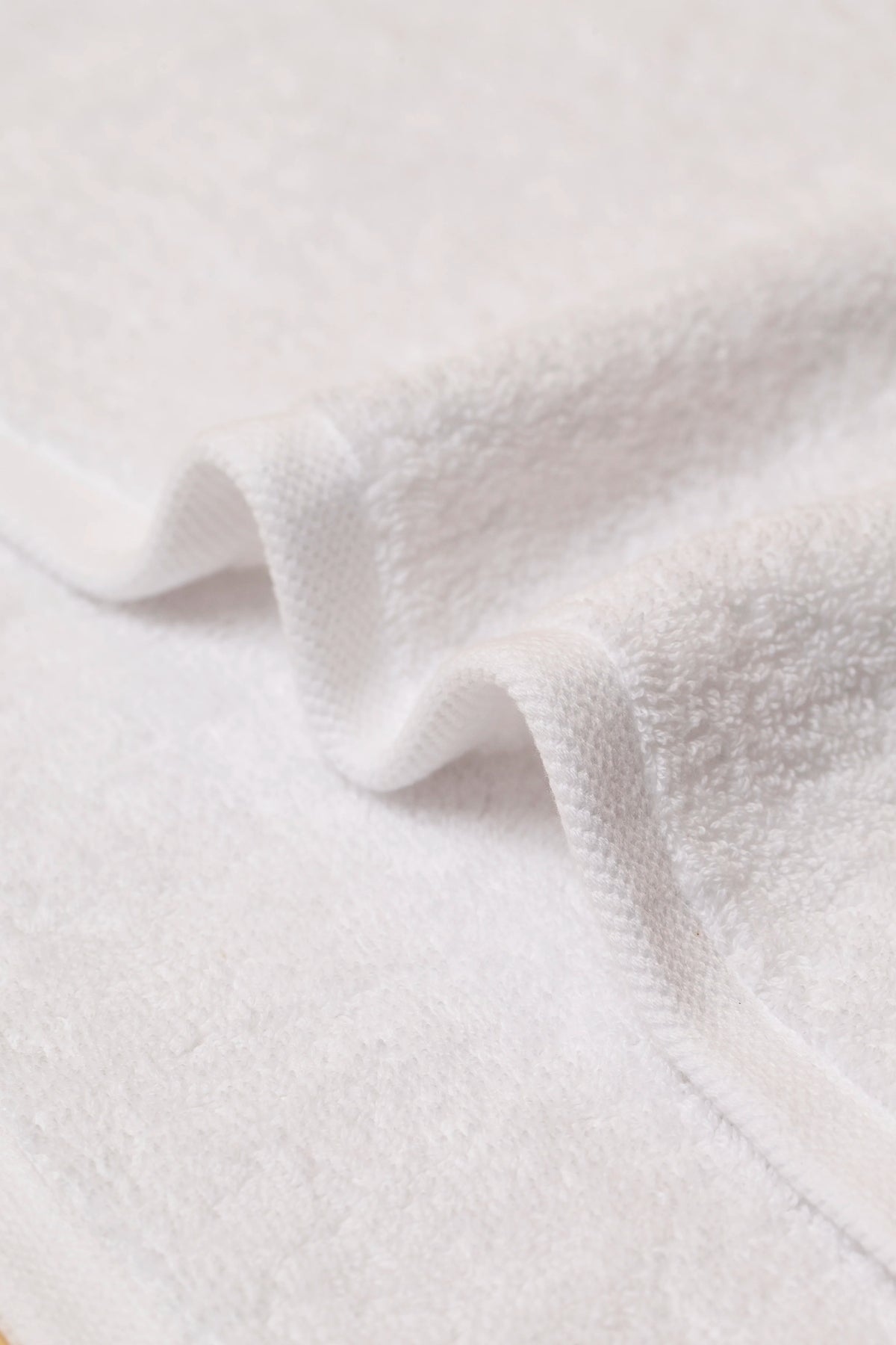 Close-up of soft white cotton terry and the flat twill hem on a Retreat towel
