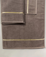 Brown Chateau Turkish cotton bath mat, close-up of the gold dobby border and soft terry pile 