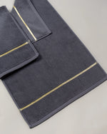 Grey Chateau Turkish cotton bath mat, close-up of the gold dobby border and soft terry pile 