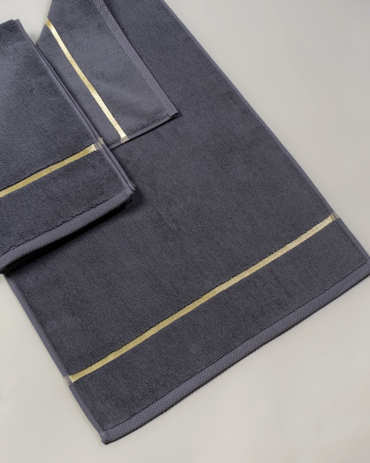 Grey Chateau Turkish cotton bath mat, close-up of the gold dobby border and soft terry pile 