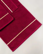 Maroon Chateau Turkish cotton bath mat, close-up of the gold dobby border and soft terry pile 