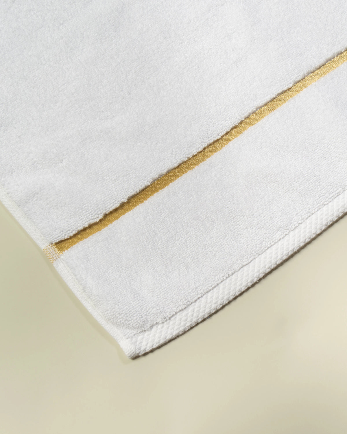 White Chateau Turkish cotton bath mat, close-up of the gold dobby border and soft terry pile 