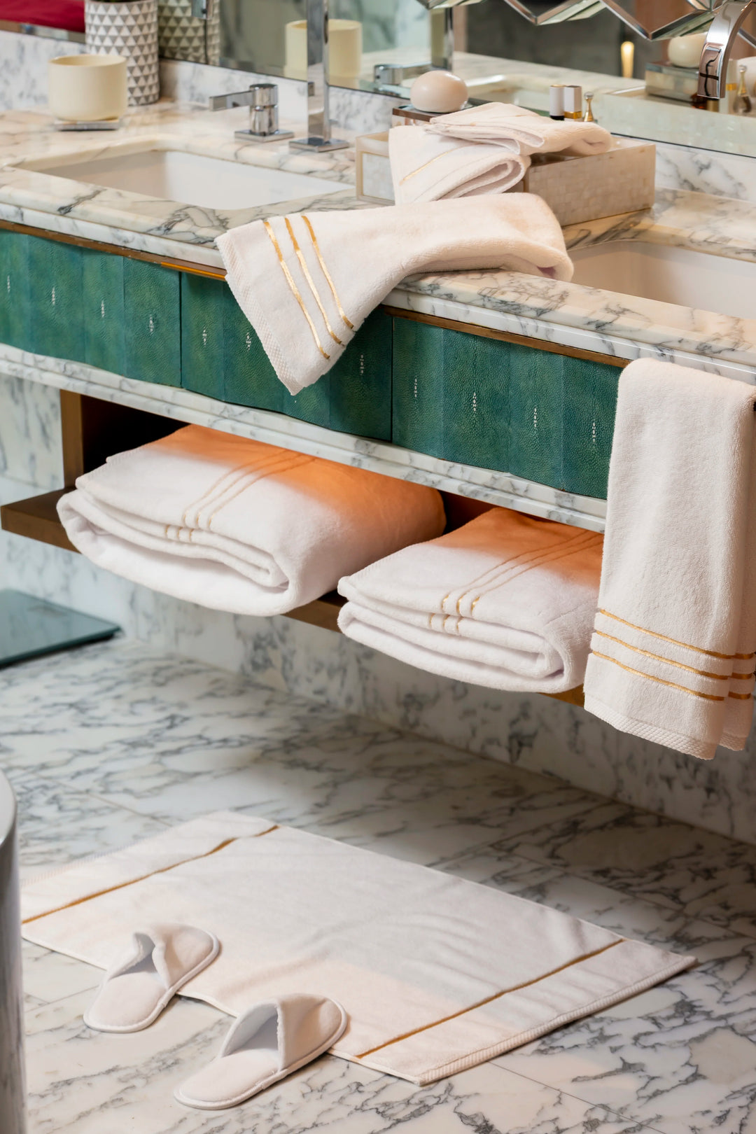 White Chateau Turkish cotton bath mat, on a marble bathroom floor with white slippers 