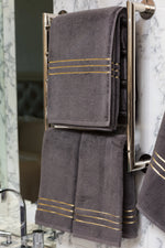 Grey Chateau Turkish cotton bath sheet, on a heated towel rail in a marble bathroom 