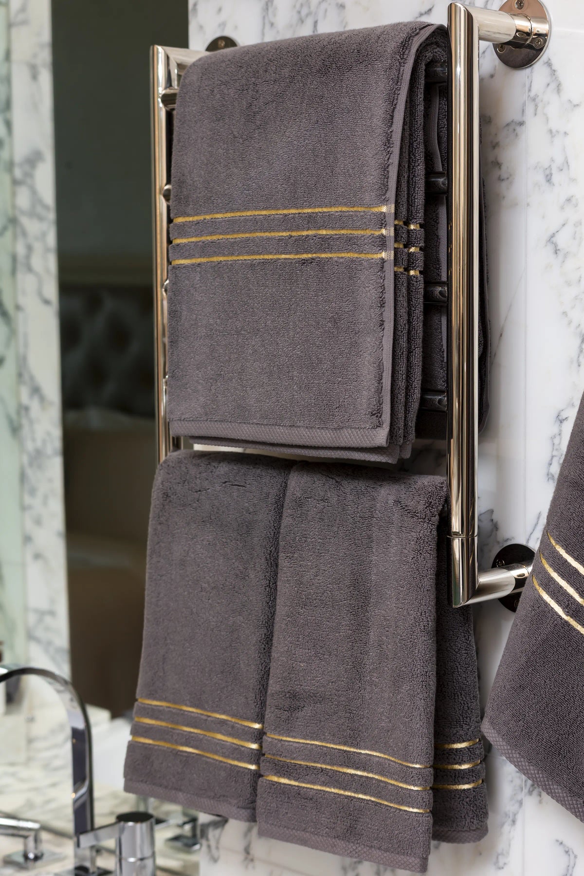 Grey Chateau Turkish cotton bath sheet, on a heated towel rail in a marble bathroom 