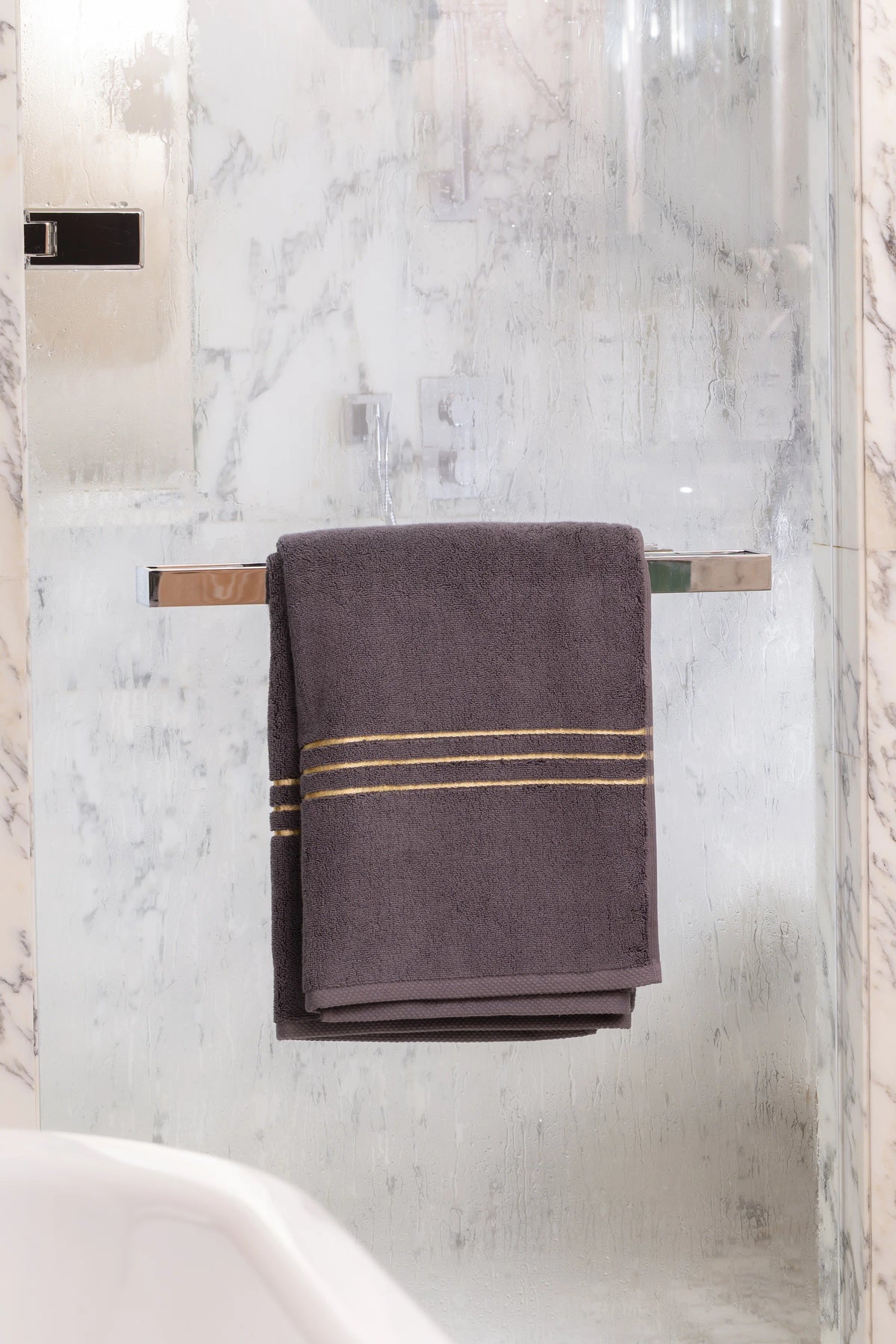 Grey Chateau Turkish cotton bath sheet, on a chrome bar in a glass shower 
