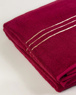 Maroon Chateau Turkish cotton bath sheet, close-up of the gold dobby border and soft terry pile 