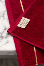 Maison 1952 Chateau Collection woven label on a maroon Turkish cotton bath sheet 