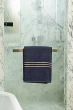 Navy Blue Chateau Turkish cotton bath sheet, on a chrome bar in a glass shower 