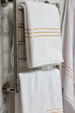 White Chateau Turkish cotton bath sheet, on a heated towel rail in a marble bathroom 