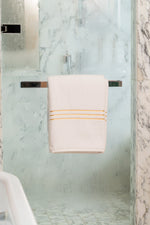 White Chateau Turkish cotton bath sheet, on a chrome bar in a glass shower 