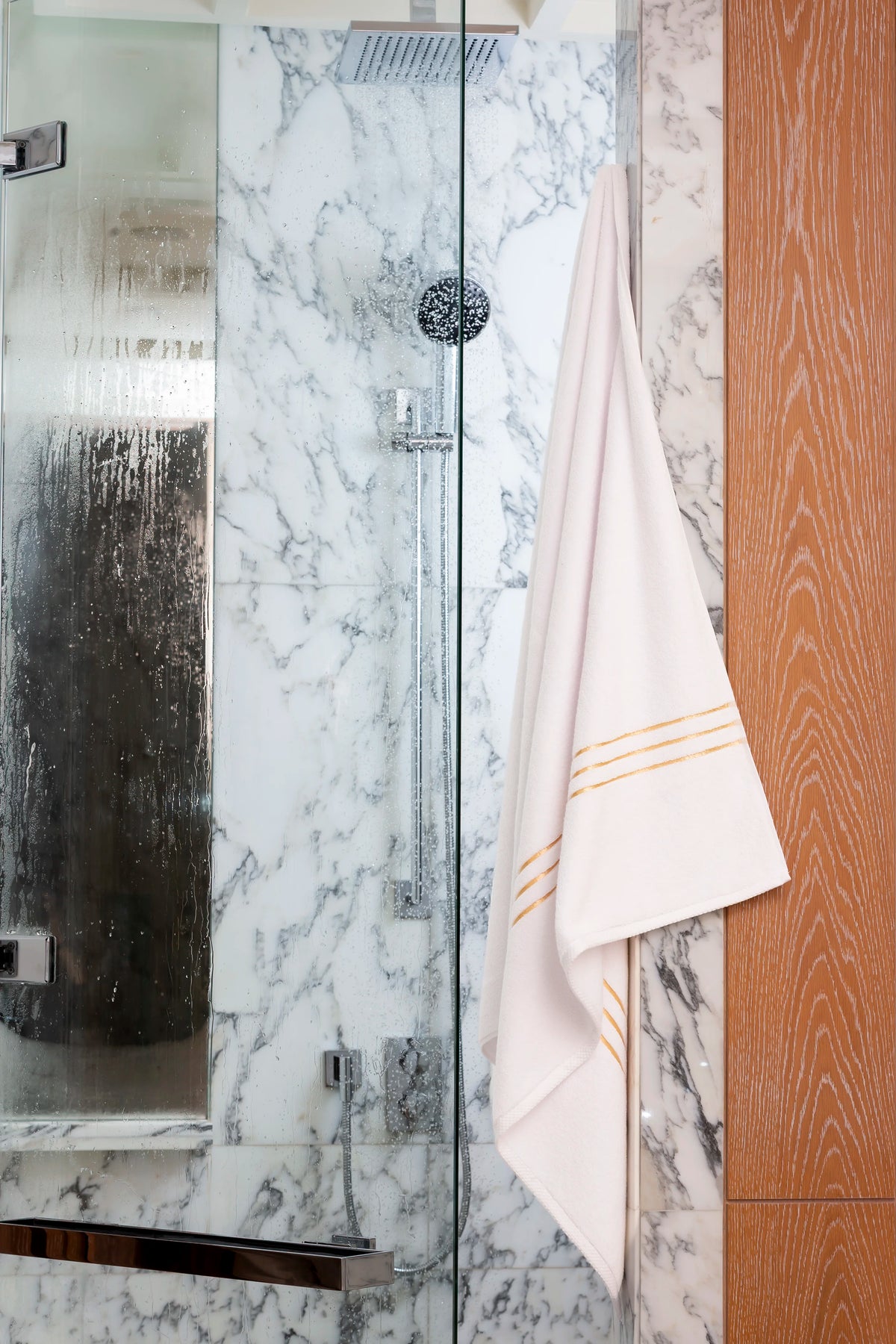 White Chateau Turkish cotton bath towel, hanging in a marble and glass shower 
