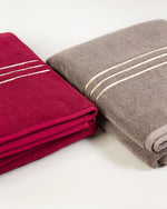 Abbinamento colori del set Chateau Duo: teli maxi da bagno bordeaux e marrone, piegati uno accanto all'altro