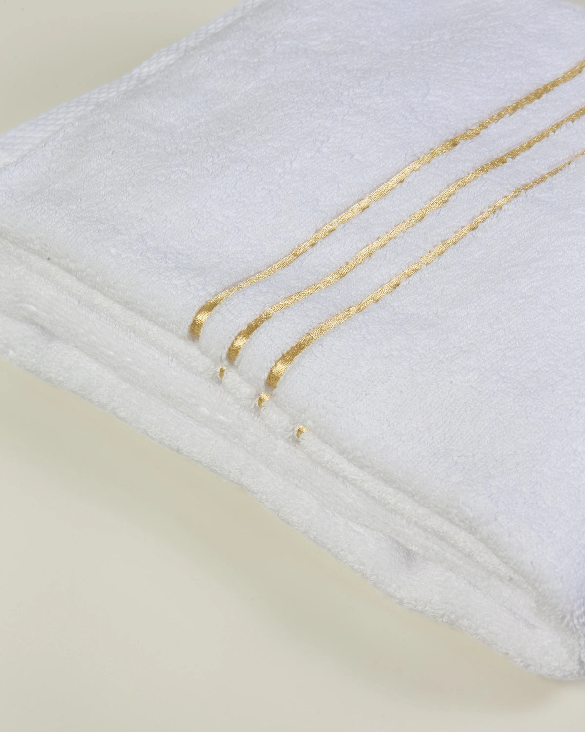 White Chateau Essentials set – close-up of the three gold lines on the folded bath towel 