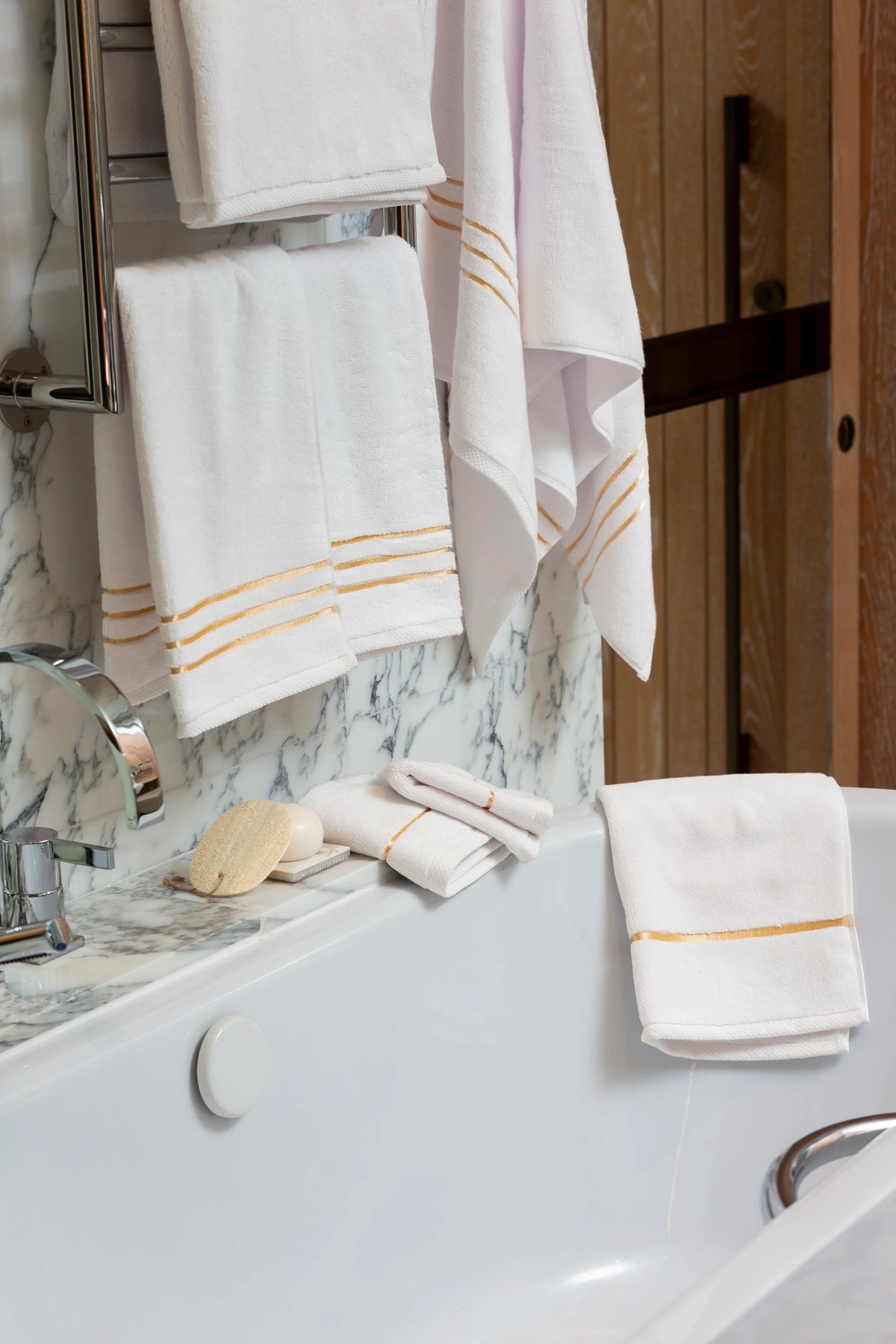 Set Chateau Essentials, colore bianco – asciugamani su uno scaldasalviette con un asciugamano sulla vasca 