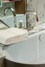 Set Chateau Essentials, colore bianco – asciugamano piegato sul bordo di una vasca 