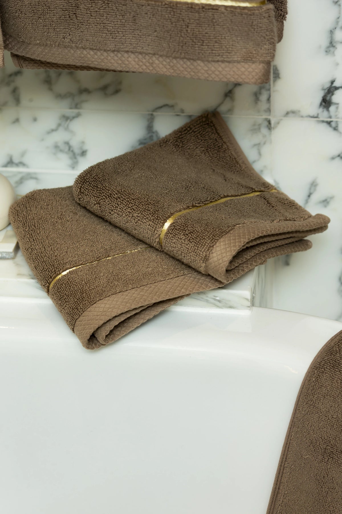 Brown Chateau Turkish cotton face towel, on a marble vanity 
