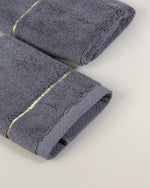 Grey Chateau Turkish cotton face towel, close-up of the gold dobby border and soft terry pile 