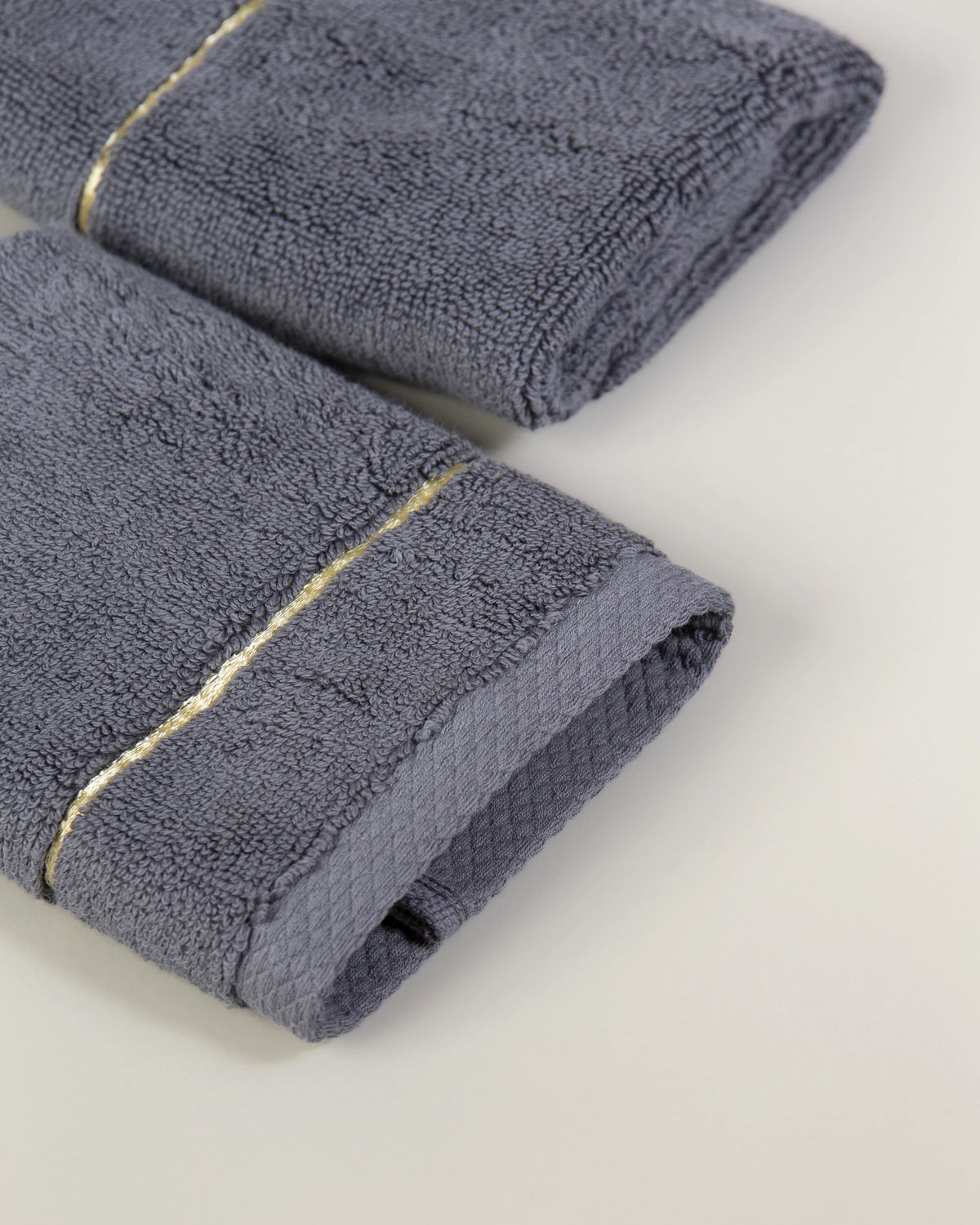 Grey Chateau Turkish cotton face towel, close-up of the gold dobby border and soft terry pile 