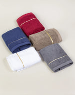 Five Chateau Turkish cotton face towels in navy blue, maroon, brown, white and grey laid out together 