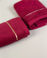Maroon Chateau Turkish cotton face towel, close-up of the gold dobby border and soft terry pile 