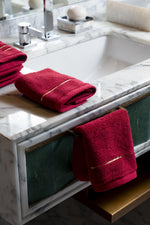 Maroon Chateau Turkish cotton face towel, on a marble vanity 