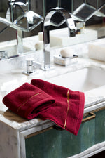 Maroon Chateau Turkish cotton face towel, on a marble vanity 