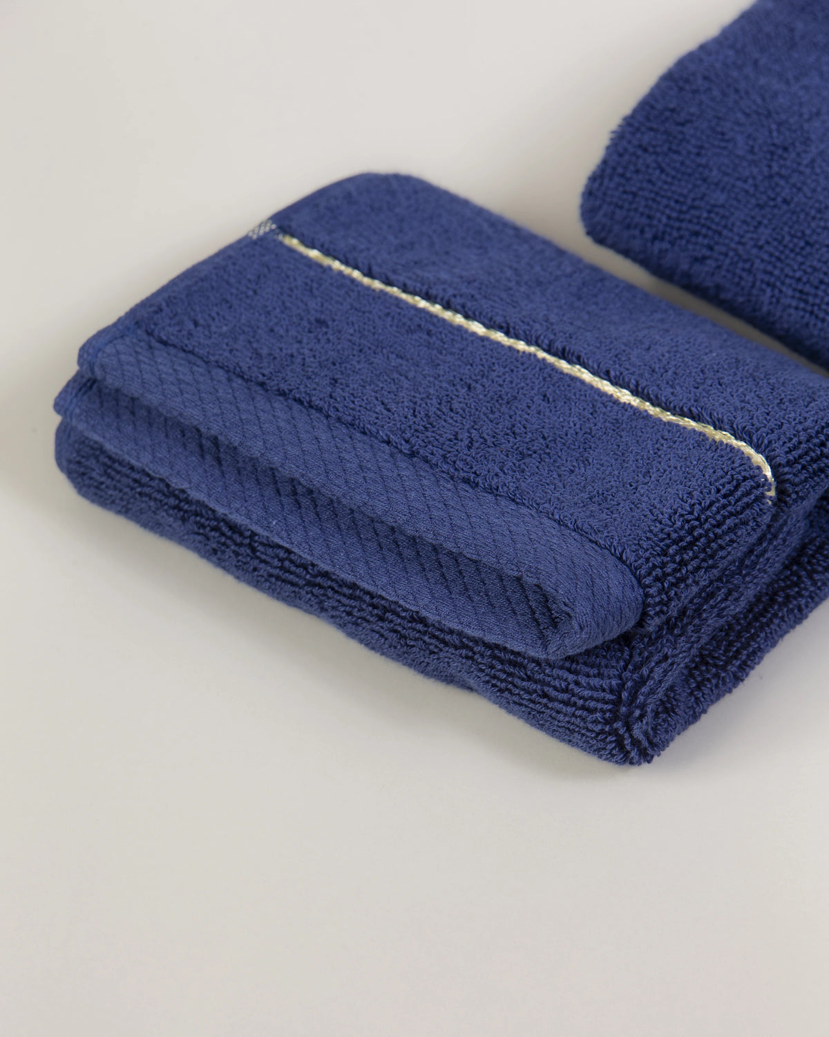 Navy Blue Chateau Turkish cotton face towel, close-up of the gold dobby border and soft terry pile 