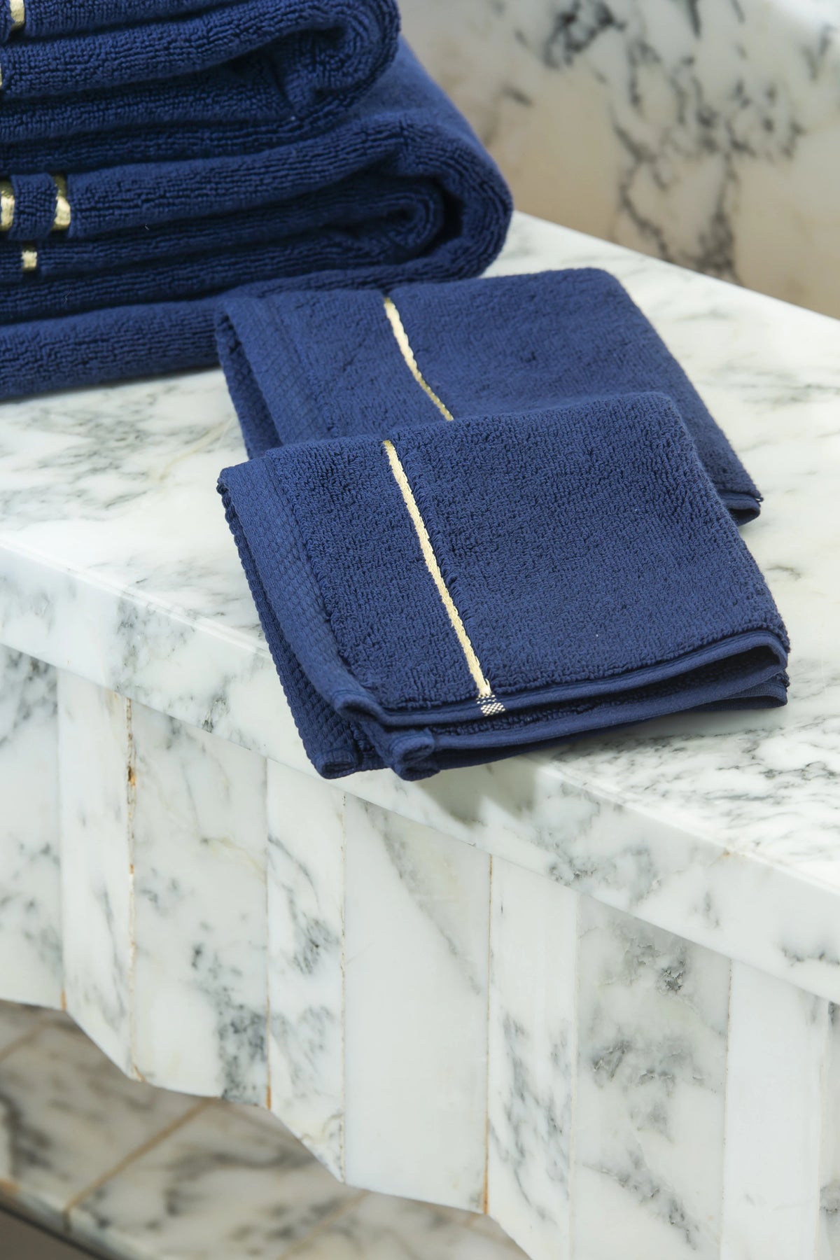 Navy Blue Chateau Turkish cotton face towel, on a marble vanity 