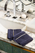 Navy Blue Chateau Turkish cotton face towel, on a marble vanity 