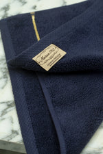 Maison 1952 Chateau Collection woven label on a navy blue Turkish cotton face towel 