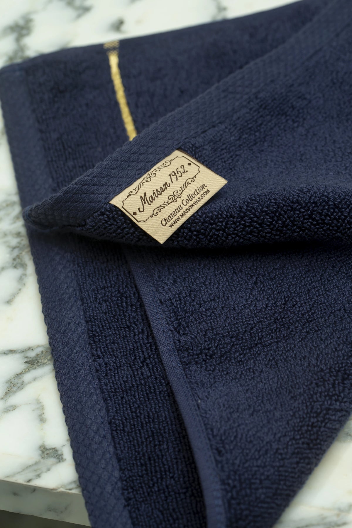 Maison 1952 Chateau Collection woven label on a navy blue Turkish cotton face towel 