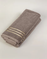 Brown Chateau Turkish cotton hand towel, folded on a soft studio backdrop 