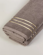Brown Chateau Turkish cotton hand towel, close-up of the gold dobby border and soft terry pile 