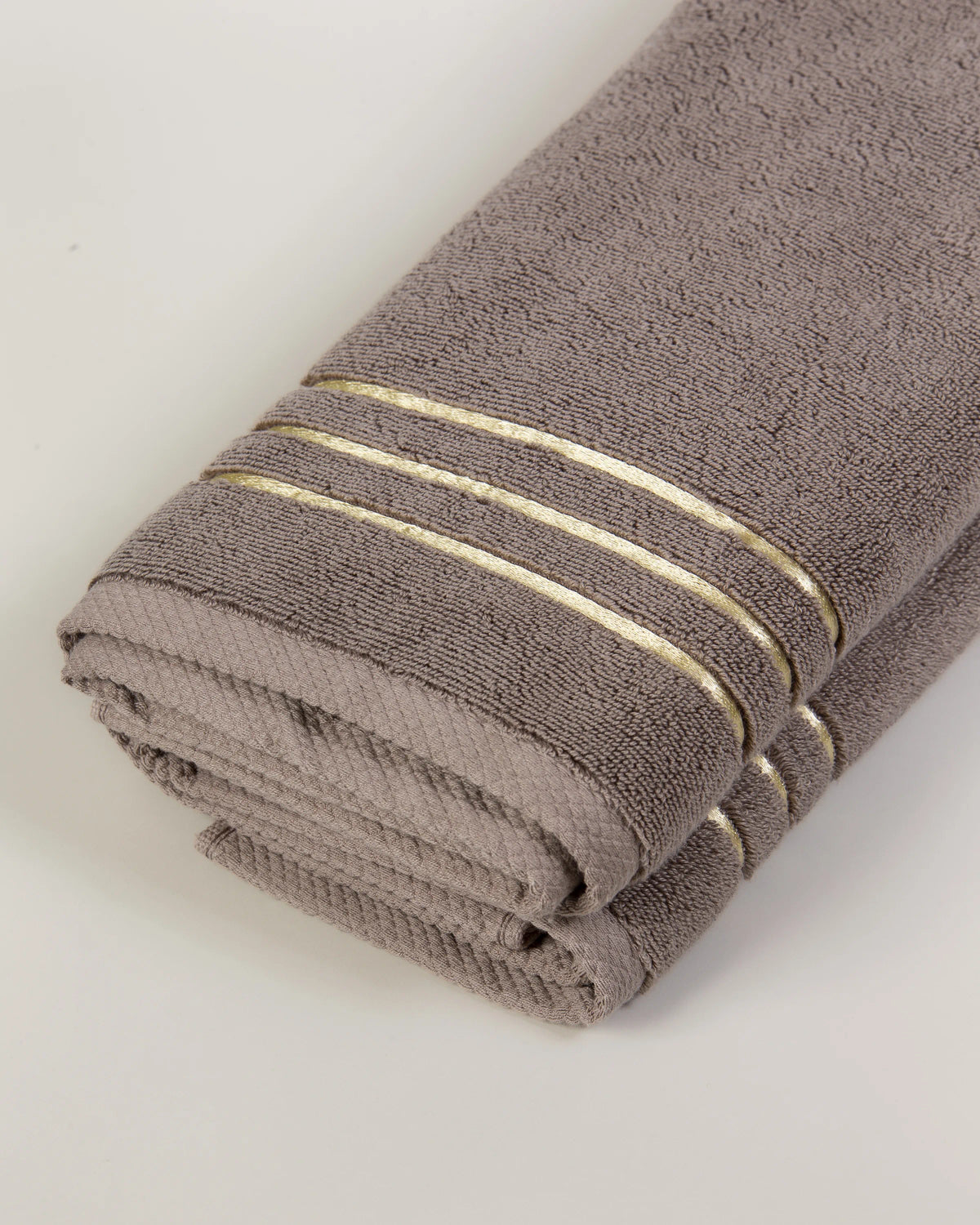 Brown Chateau Turkish cotton hand towel, close-up of the gold dobby border and soft terry pile 