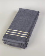 Grey Chateau Turkish cotton hand towel, folded on a soft studio backdrop 