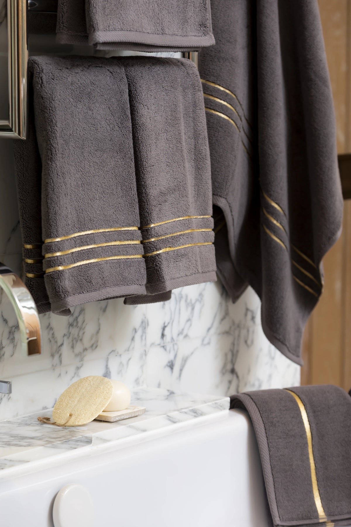 Grey Chateau Turkish cotton hand towel, hanging beside a marble bathtub 