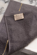 Maison 1952 Chateau Collection woven label on a grey Turkish cotton hand towel 