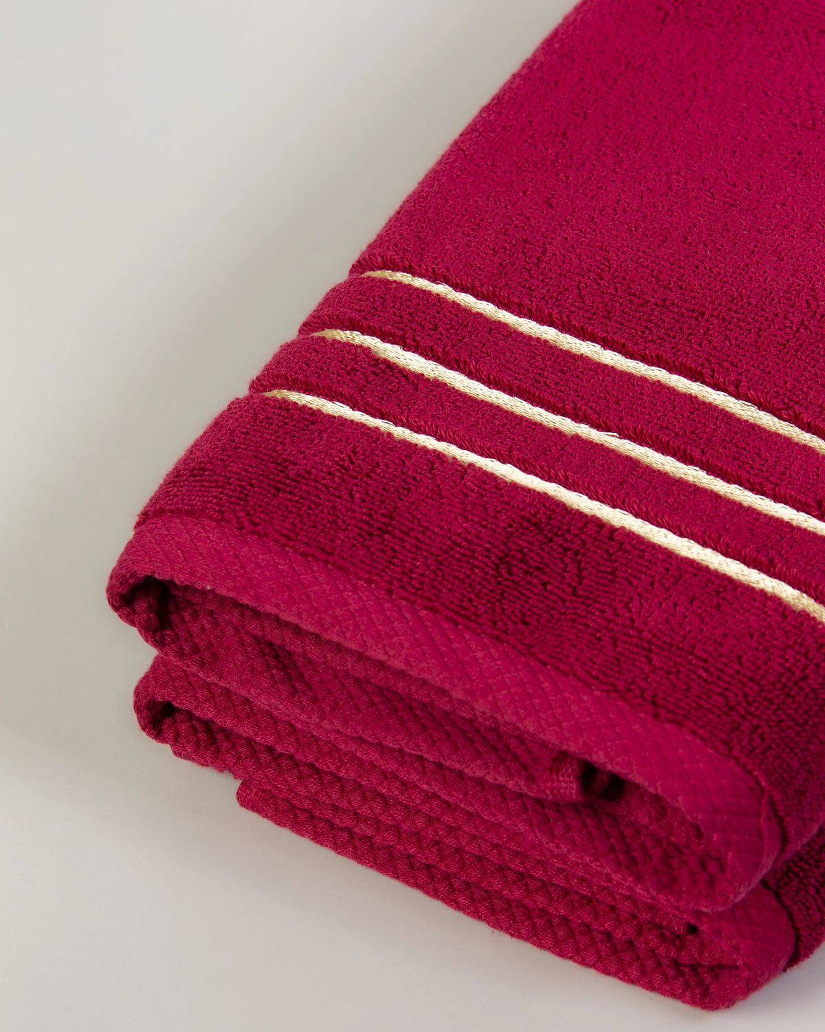 Maroon Chateau Turkish cotton hand towel, close-up of the gold dobby border and soft terry pile 