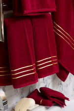 Maroon Chateau Turkish cotton hand towel, hanging beside a marble bathtub 
