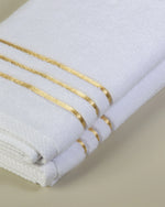 White Chateau Turkish cotton hand towel, close-up of the gold dobby border and soft terry pile 