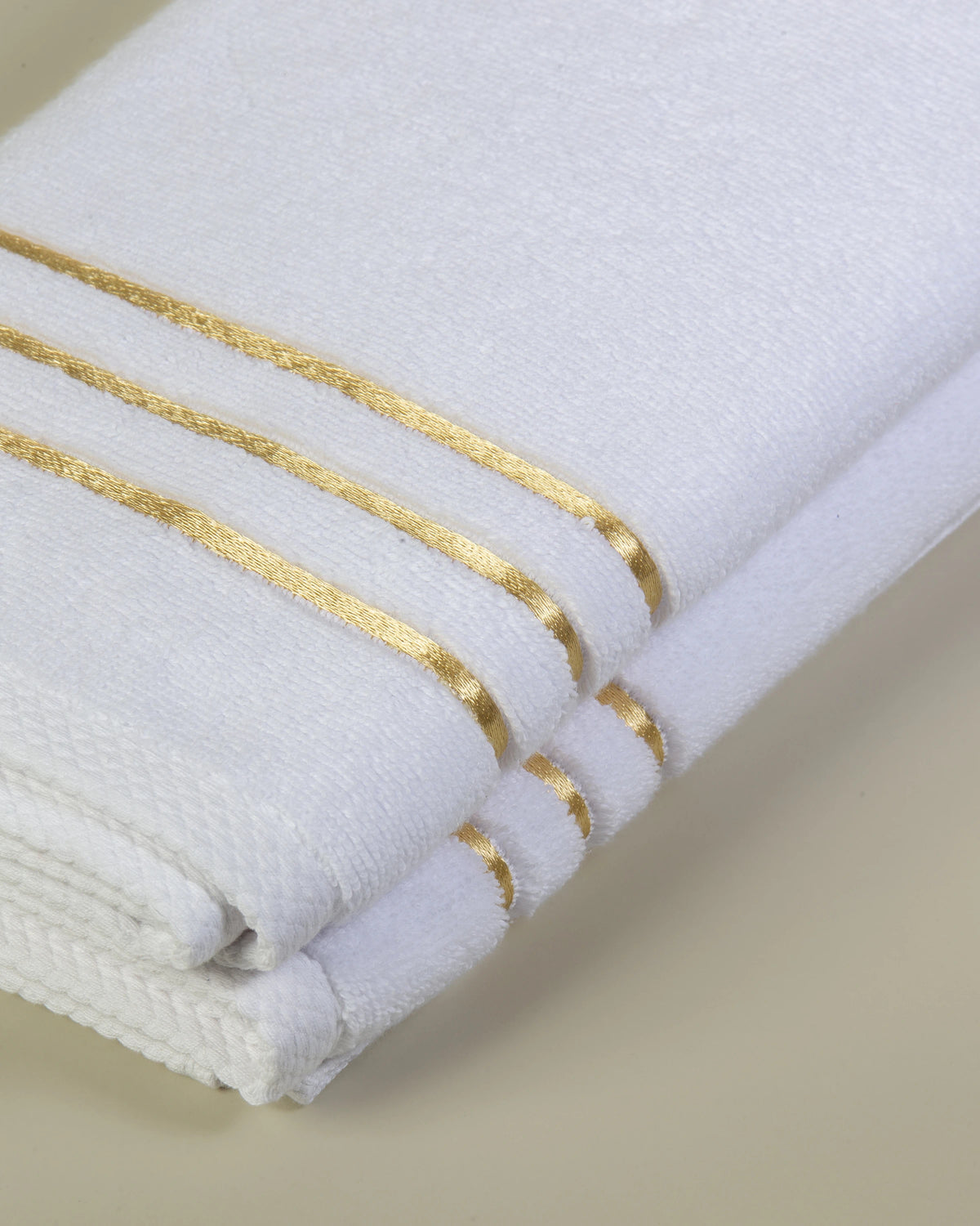 White Chateau Turkish cotton hand towel, close-up of the gold dobby border and soft terry pile 