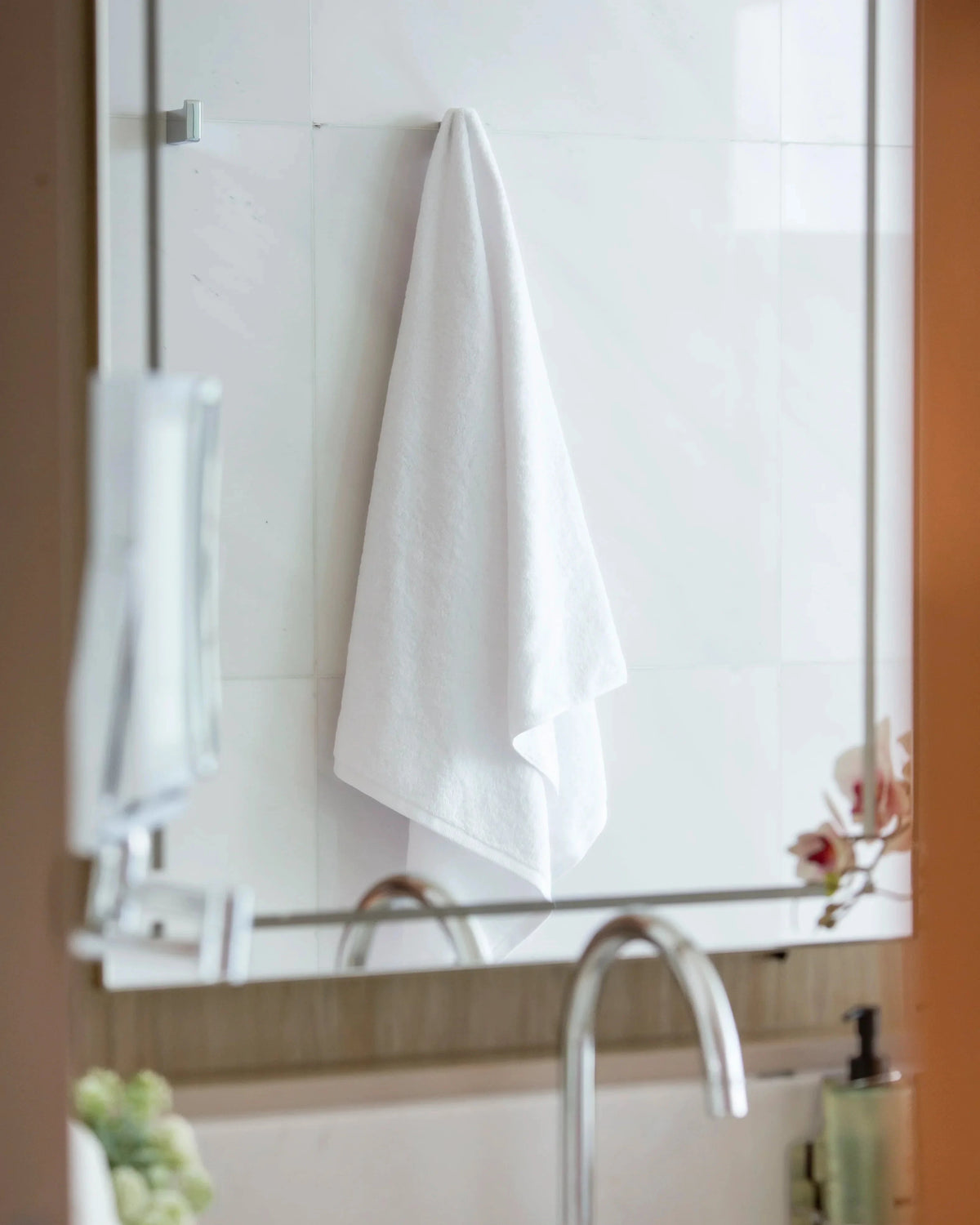 Retreat white cotton bath towel hanging on a hook in a marble bathroom