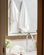 Retreat Complete Set white cotton towels hanging in a marble bathroom