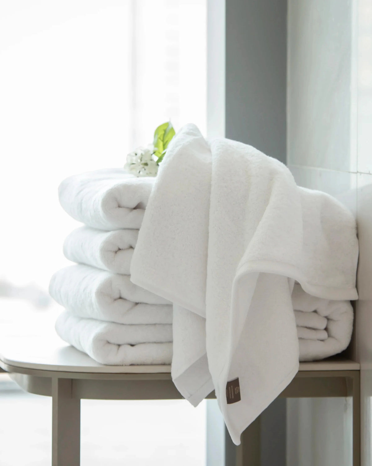 Retreat Duo Set white cotton towels folded and draped on a console table