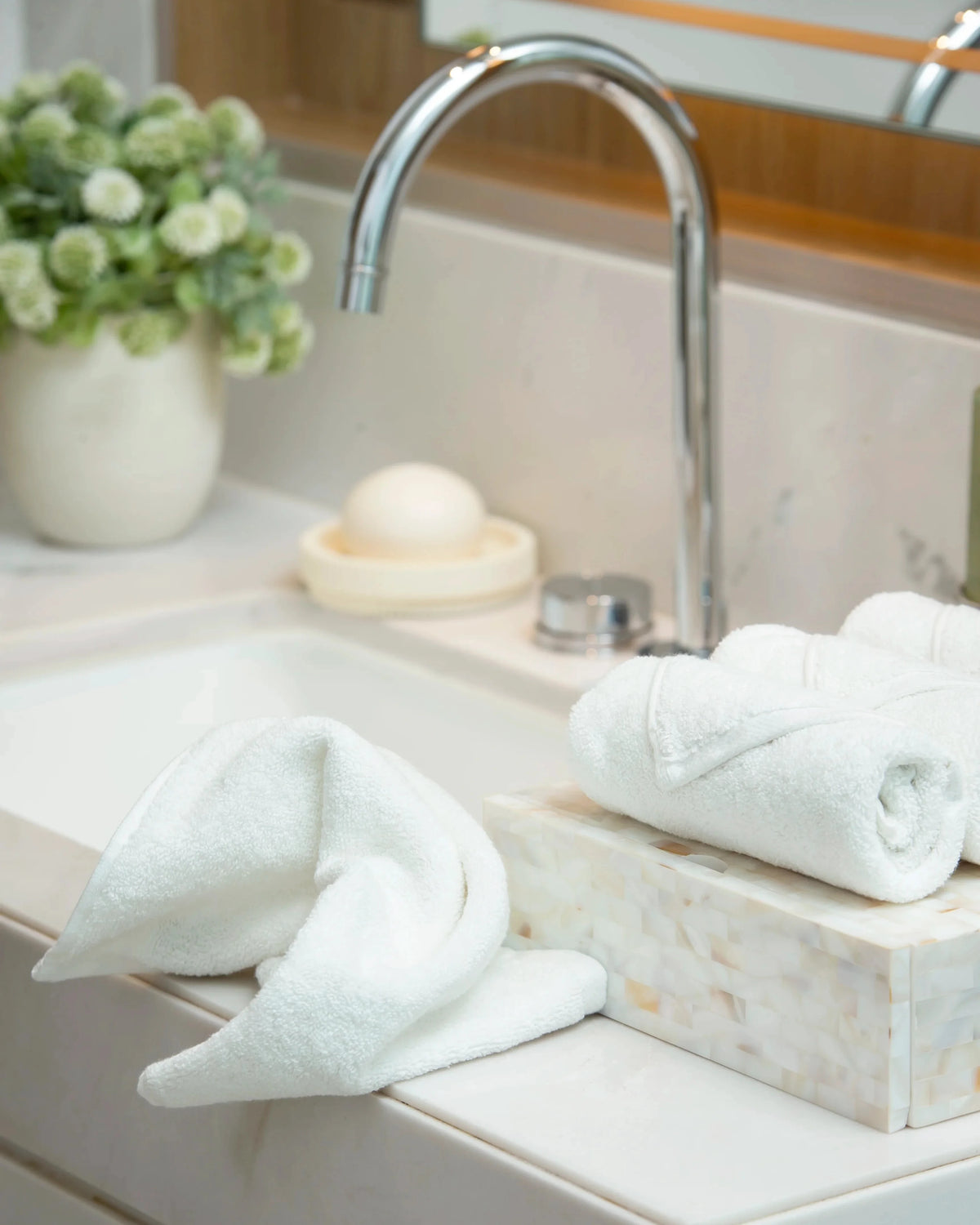 Retreat white cotton face towel draped on a marble washbasin ledge