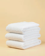 Maison 1952 Retreat hand towel in white, 650 GSM 100% cotton, stack of three folded towels
